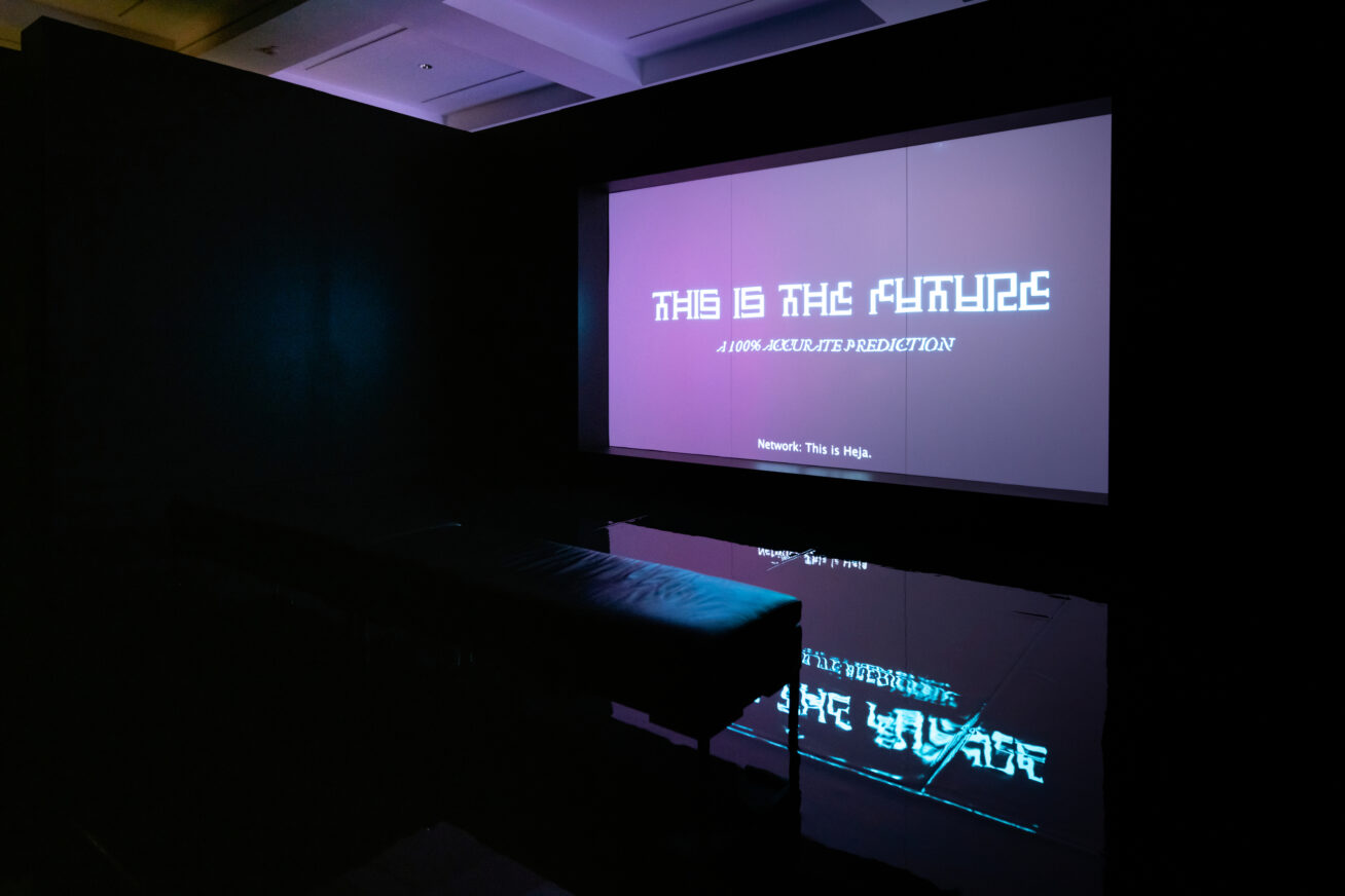 Dark room with a large screen that says "This is the Future"